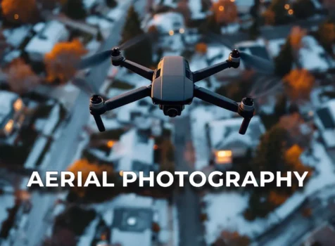 A drone flying over a snow-covered suburban neighborhood at dusk, with the text 'Aerial Photography' displayed in bold letters.